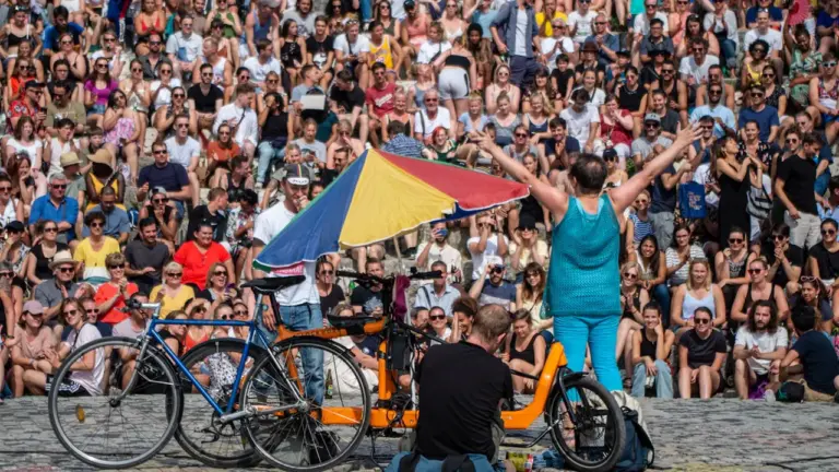 Zwei Personen mit einem Lastenfahrrad vor einem großen Publikum im Mauerpark in Berlin.
