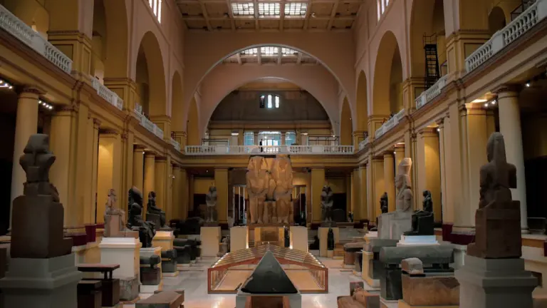 Weitläufige Ausstellungshalle mit zahlreichen antiken ägyptischen Statuen und Exponaten in einem Museum.