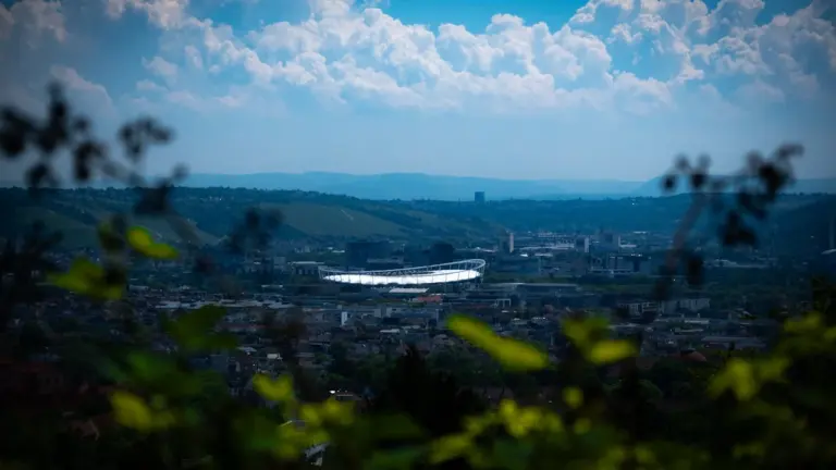 Panoramablick auf die MHP Arena in Stuttgart Bad Cannstatt inmitten einer grünen Landschaft.