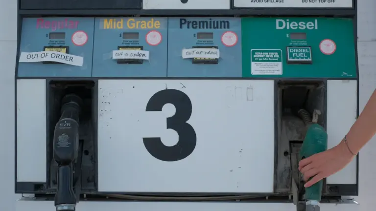 Eine weiß-grüne Zapfsäule an einer Tankstelle in München im Tageslicht.