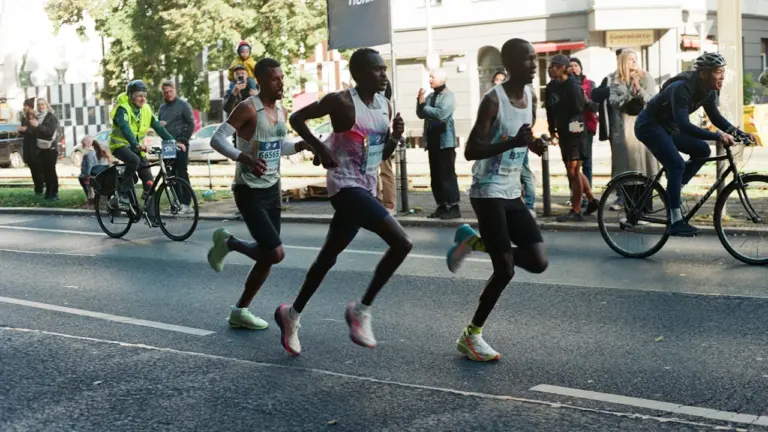 Spitzenläufer beim Berlin-Marathon auf einer breiten Straße im Stadtzentrum.