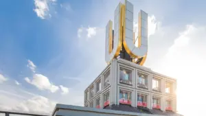 Das Dortmunder U mit seinem ikonischen, golden leuchtenden U-Logo vor einem strahlend blauen Himmel.