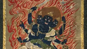 Eine dreiköpfige, dunkelblaue buddhistische Gottheit mit sechs Armen vor einem lodernden, roten Flammenhintergrund.