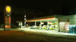 Shell Tankstelle bei Nacht mit verschneitem Boden in einer deutschen Umgebung.
