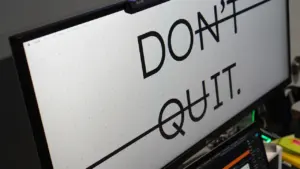 Ein Computerbildschirm zeigt den durchgestrichenen Text Don't Quit als motivierende Nachricht.