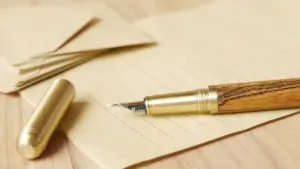 Ein Füllfederhalter auf beschriftetem Papier, Symbol für Kommunikation, Fristen und bürokratische Sorgfalt.