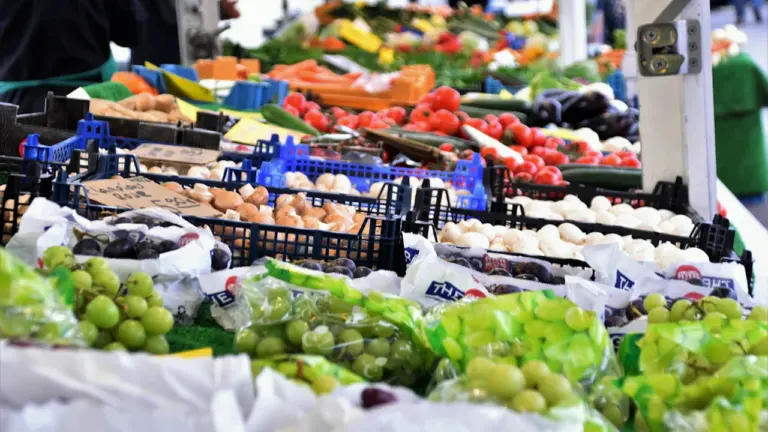 Bunte Auswahl an frischem Obst und Gemüse auf einem traditionellen Wochenmarktstand.