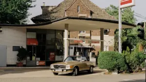 Ein klassischer Oldtimer parkt an einer deutschen Tankstelle in Köln.