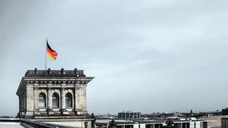 Luftaufnahme des historischen Reichstagsgebäudes in Berlin unter blauem Himmel.