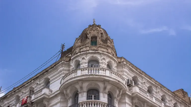Historisches Gebäude mit prachtvoller Kuppel unter einem klaren blauen Himmel in der Sonne.
