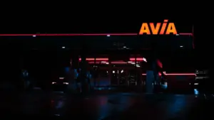 Neon-beleuchtetes Tankstellen-Schild bei Nacht in einer deutschen Stadt.