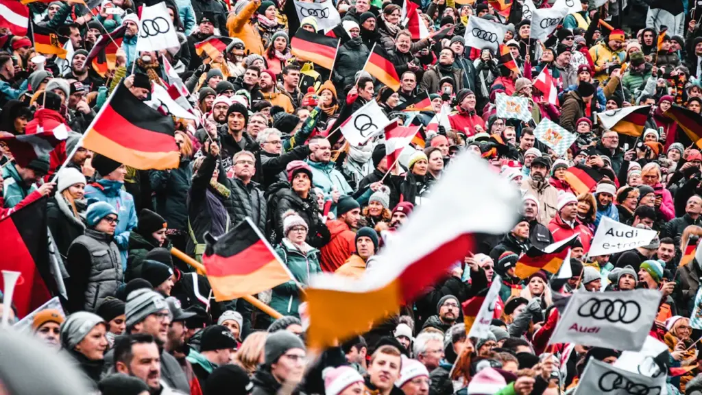 Menschenmenge in Deutschland schwenkt deutsche Flaggen bei einer feierlichen öffentlichen Veranstaltung.